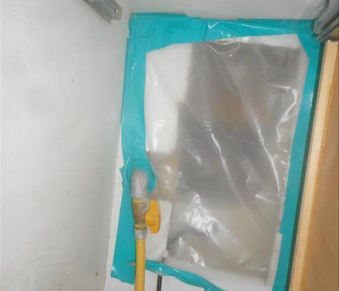 Pipe leak in between cabinetry.